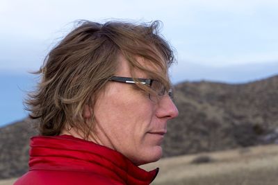 Close-up of man looking away against sky