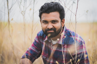 Portrait of smiling young man by plants