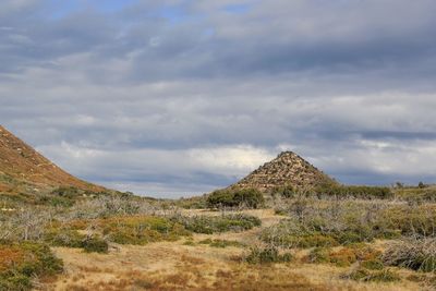 View of countryside landscape against cloudy sky