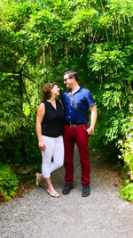 Young couple standing against trees