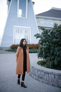 Portrait of woman standing against building