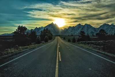 Empty road against sky during sunset