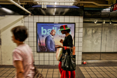 Rear view of people walking in subway station