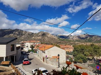 Houses by mountains against sky