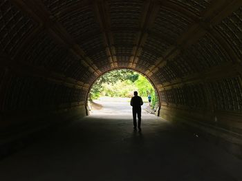 Silhouette of man walking in tunnel