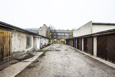 Footpath amidst buildings against sky