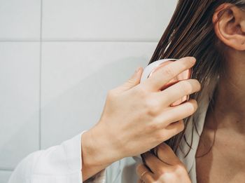 Woman brushing hair in the bathroom