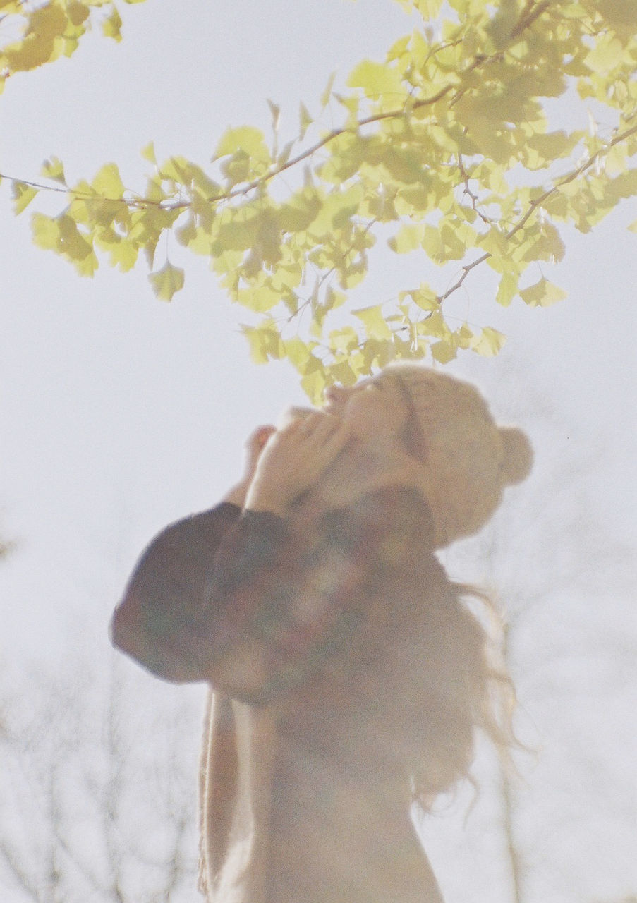 WOMAN WITH DOG BY FLOWER TREES