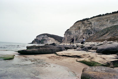 Rocks on beach against clear sky