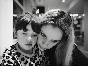 Close-up of mother embracing cute daughter at home