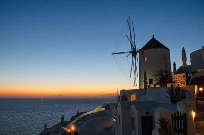 An old windmill in the village of oia on the island of santorini, greece at sunset. 