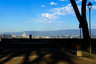 Silhouette people standing on bridge against sky