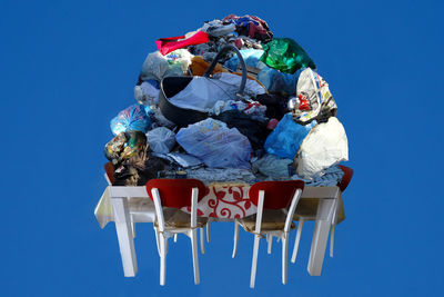 Heap of garbage on table against blue background