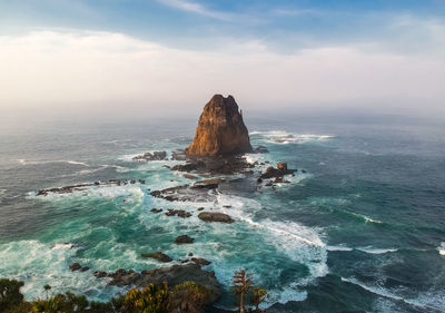 Scenic view of rocks in sea against sky