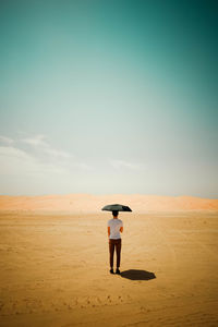 Rear view of man standing on beach