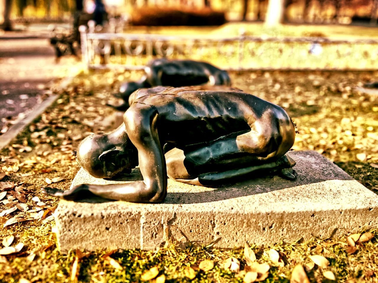 focus on foreground, day, park - man made space, full length, outdoors, selective focus, sculpture, close-up, street, statue, sunlight, shoe, human representation, field, childhood, stone material, art and craft, stone - object