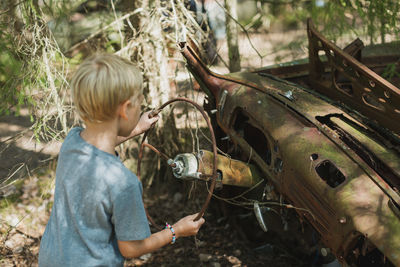 Boy playing in wrecked car