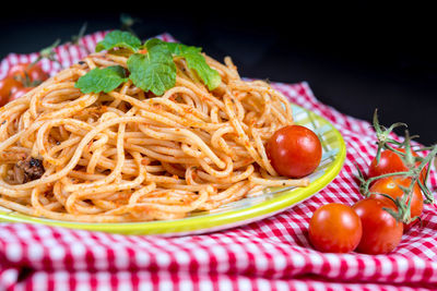 Bolognese in plate by tomatoes on fabric