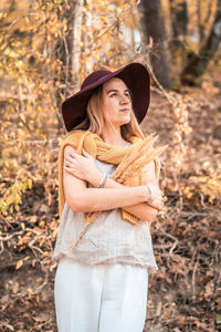 Young woman wearing hat standing in forest