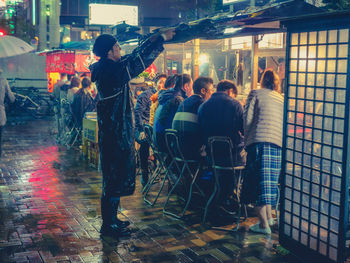 People in illuminated city at night