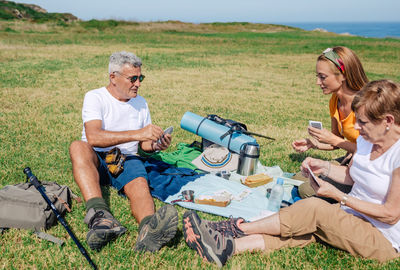 Adult family having a picnic and playing cards during an excursion