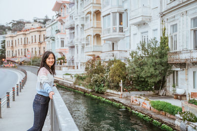 Portrait of young woman standing in city