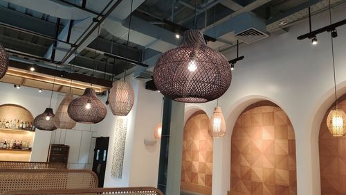 Low angle view of illuminated chandelier hanging on ceiling