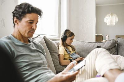 Young man using mobile phone while sitting on sofa