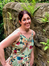 Portrait of smiling young woman standing on rock