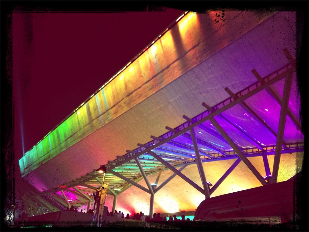 illuminated, transfer print, built structure, night, architecture, low angle view, auto post production filter, lighting equipment, sky, blue, light - natural phenomenon, building exterior, railing, metal, connection, no people, outdoors, dusk, bridge - man made structure