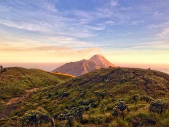 Scenic view of mountain range against cloudy sky