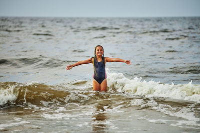 Young woman jumping in sea
