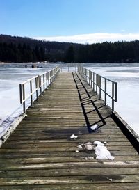 Boardwalk on beach against clear sky