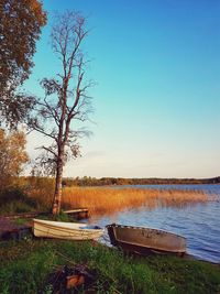 Abandoned boat moored in lake against clear sky