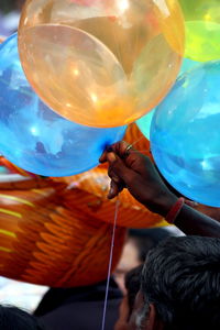 Cropped image of man holding balloons for sale