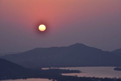 Scenic view of silhouette mountains against sky during sunset