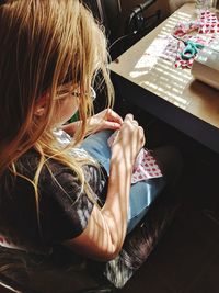 High angle view of woman sewing textile at home