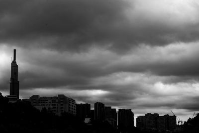 Buildings in city against cloudy sky