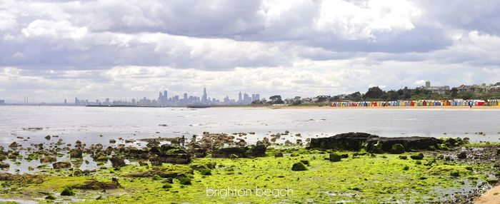 View of cityscape against cloudy sky