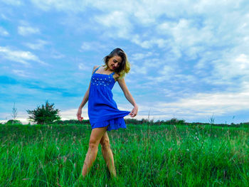 Portrait of young woman standing on field