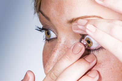Close-up portrait of a woman putting contact lenses in