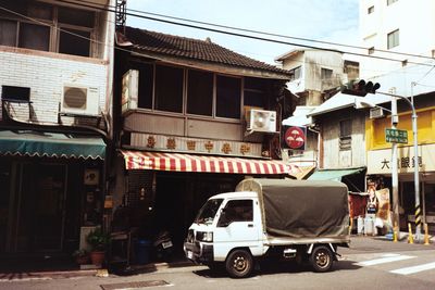 Cars on street against buildings in city