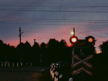 Electricity pylon against sky during sunset