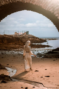 Rear view of woman walking at beach