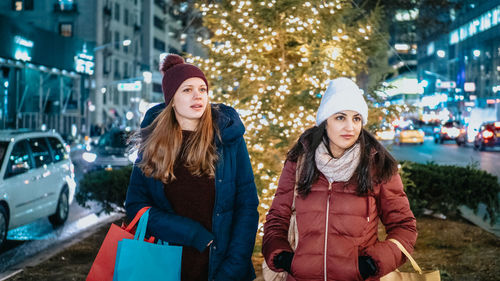 Young woman standing on street in city during winter