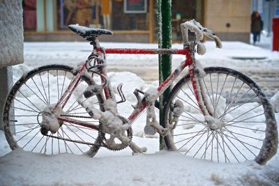 Snow covered bicycle wheel during winter