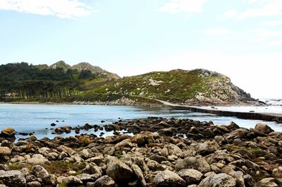 Rocks by sea against sky