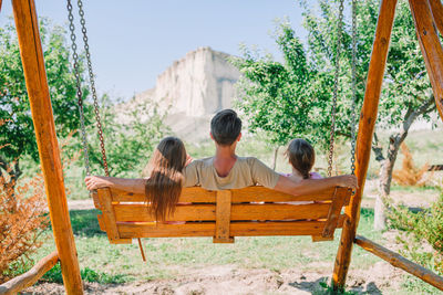 Rear view of family sitting on swing