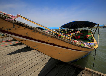 Ship moored on pier against sky