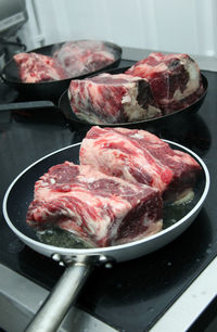 Beef in cooking pans on stove at home